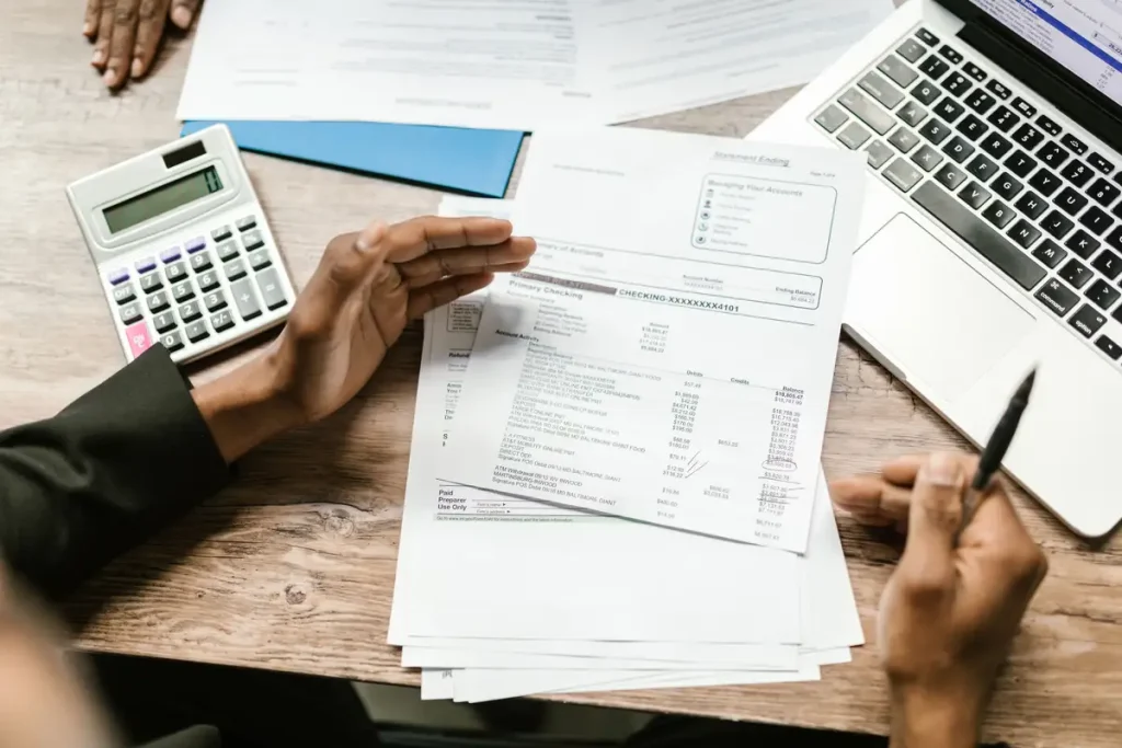 Freelancer invoice Pakistan — freelancer reviewing billing documents with a calculator and laptop